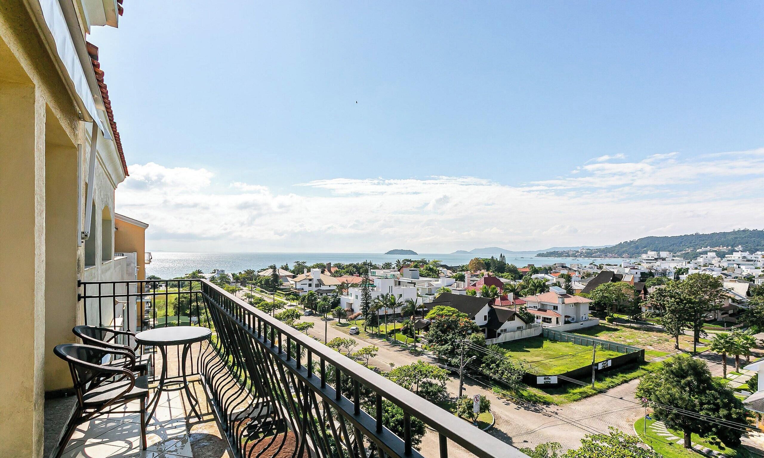 A balcony with a view of a coastal town, including houses and a beach.