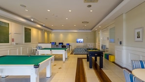 A room with multiple pool tables, a sofa, and a television. - Beautiful Penthouse Luxury Resort Jurere Ilc2505 (Florianópolis)