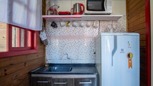 Cuina compacta amb nevera, microones, bullidor i rentamiques.