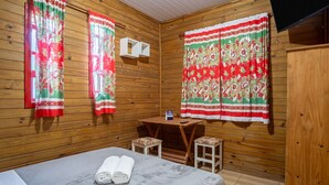 A wooden cabin room with two windows, a wooden table, two stools, and a rolled-up towel on the floor. - Charming Cabin 11 Minutes From Rosa Beach Prj001 (Imbituba)