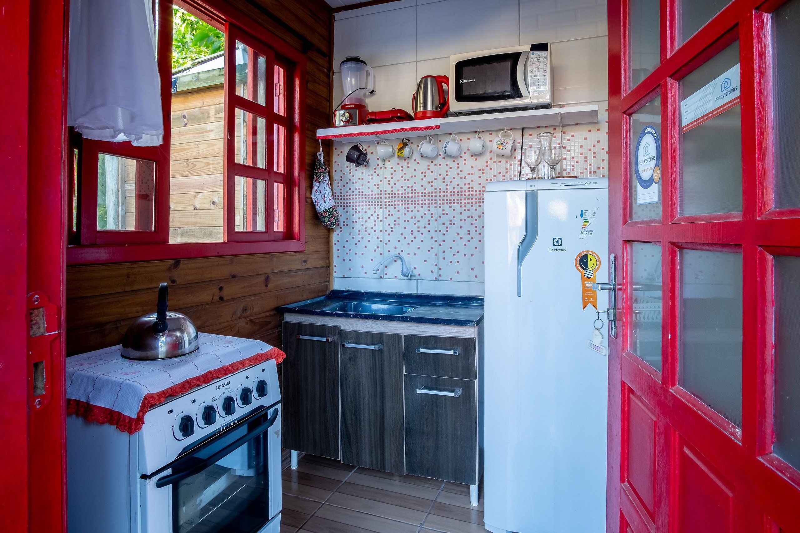 A compact kitchen with a stove, oven, microwave, and refrigerator.