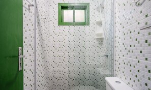 A small, enclosed shower area with white tiled walls and a green-framed window. - Cozy Cabin in Praia do Rosa - Prj003 (Imbituba)