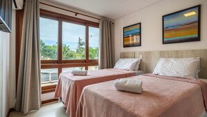 A hotel room with two beds, a large window with curtains, and two paintings on the wall. - Two-story Apt 200m From Barra Grande Beach Cpr0207 (Maraú)