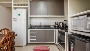 A compact kitchen with a refrigerator, microwave, coffee maker, and a small oven. - Two-story Apt 200m From Barra Grande Beach Cpr0207 (Maraú)
