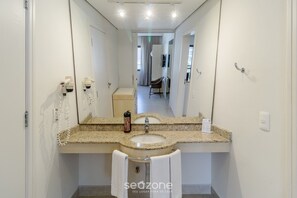 Une salle de bain avec un lavabo à vasque en granit, un miroir et un porte-serviettes.