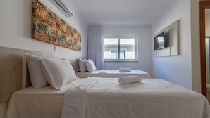 A hotel room with two beds, a large window, a flat-screen TV, and a tropical artwork on the wall. - House in Condo With Pool Near the Beach Mgi025 (Porto Seguro)