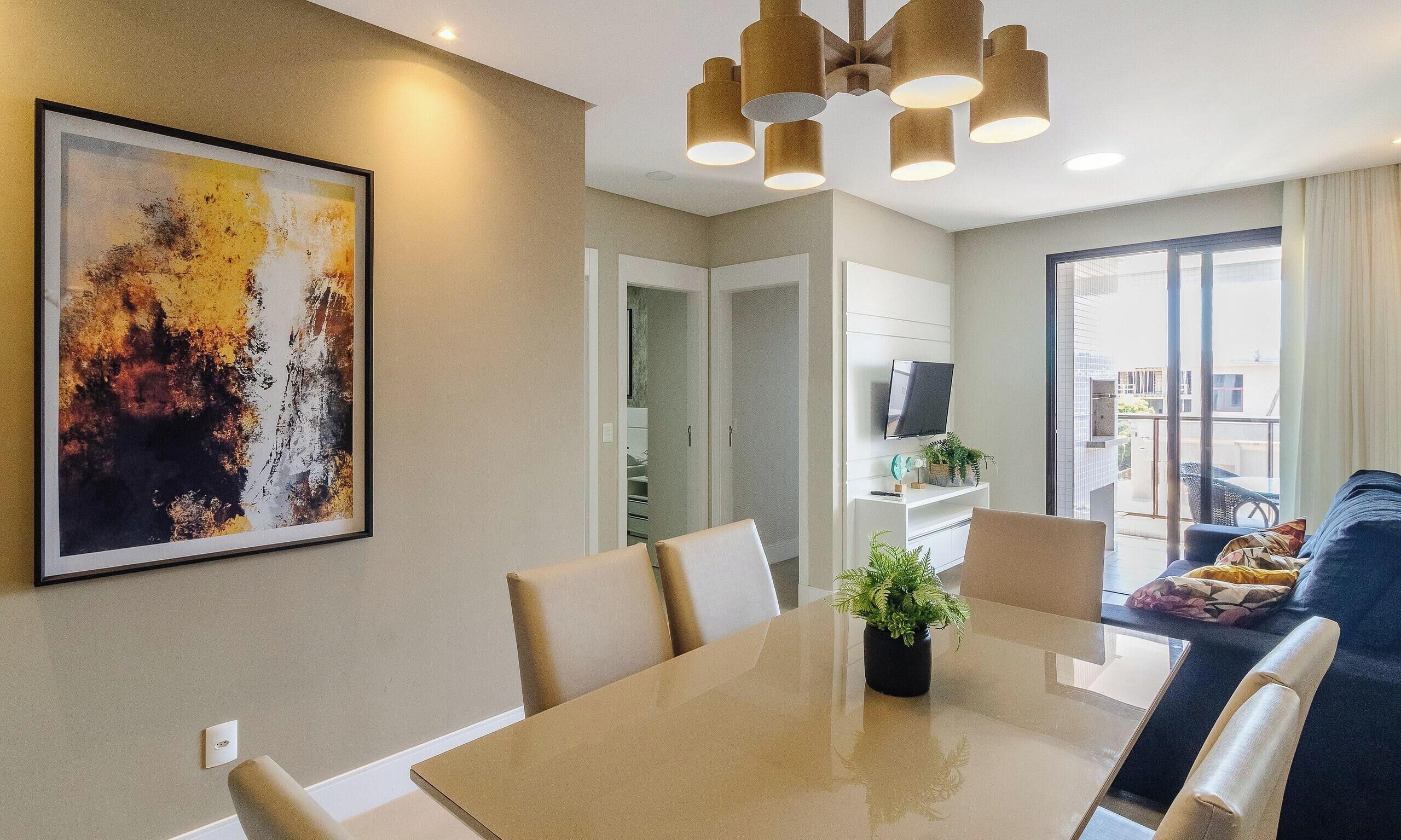 A modern dining area with a large table, chairs, and a ceiling light fixture.