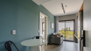 A modern living room with a dining area, a sofa, a TV, and a balcony with a view. - Charming Modern Apartment in Santo Amaro Noa0704 (São Paulo)