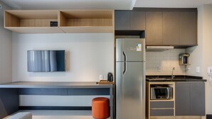 A modern kitchen with built-in appliances, a flat-screen TV, and a microwave. - Charming Modern Apartment in Santo Amaro Noa0704 (São Paulo)