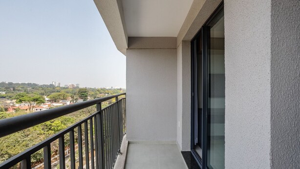 A balcony with a view of a cityscape, a glass door, and a tiled floor. - Charming Modern Apartment in Santo Amaro Noa0704 (São Paulo)