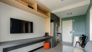 A modern kitchen with a built-in oven, a refrigerator, and a flat-screen TV mounted on the wall. - Charming Modern Apartment in Santo Amaro Noa0704 (São Paulo)
