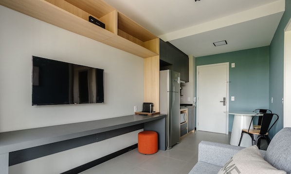 A modern kitchen with a built-in oven, a refrigerator, and a coffee maker on the counter. - Charming Modern Apartment in Santo Amaro Noa0704 (São Paulo)