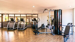 Uma academia com esteiras, elípticos e equipamentos de musculação.