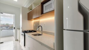 Una cocina moderna con microondas integrado, electrodomésticos de acero inoxidable y encimera de granito.