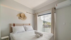 Habitación de hotel con cama, un adorno en la pared y vista al exterior.
