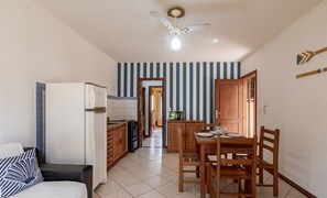 Uma cozinha compacta com geladeira, micro-ondas e armários de madeira.