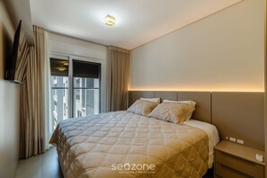 Ein modernes Hotelzimmer mit einem großen Bett, einem Nachttisch und einem Vorhangfenster.