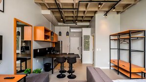 A compact living space with a kitchenette, seating area, and storage units. - Amazing Studio 750m From Canas Beach Tps105 (Florianópolis)