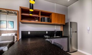 Eine moderne Küche mit schwarzem Arbeitsplatz, Edelstahlgeräten und Holzausstattung.