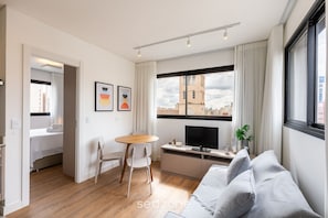 A modern apartment with a dining area, kitchenette, and a large window with a city view. - Functional Apt w/ Garage in Curitiba Wsh0801 (Curitiba)