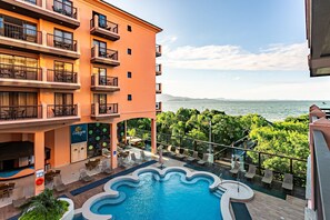 A hotel with a pool, outdoor seating, and a view of the sea. - Wonderful Suite in a Beachfront Resort Jbv108 (Florianópolis)