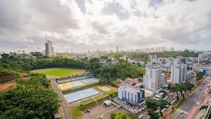 Eine Stadtansicht mit einem großen Park, Sportplätzen und modernen Gebäuden.