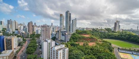 A cityscape with high-rise buildings, a green park, and a sports field.