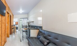 Una cocina moderna con estufa a gas, refrigerador y barra con taburetes.