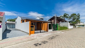 Una casa moderna con garaje, un pequeño porche y un camino de entrada pavimentado.