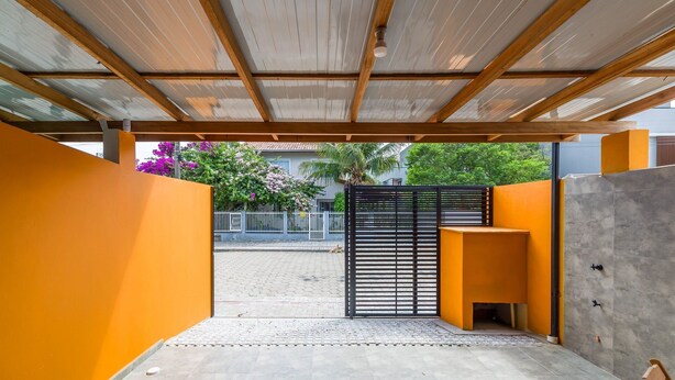 An outdoor covered area with a metal roof, a black gate, and a concrete wall. - 2BR House w/ BBQ 270m From Beach Ruc0002 (Bombinhas)