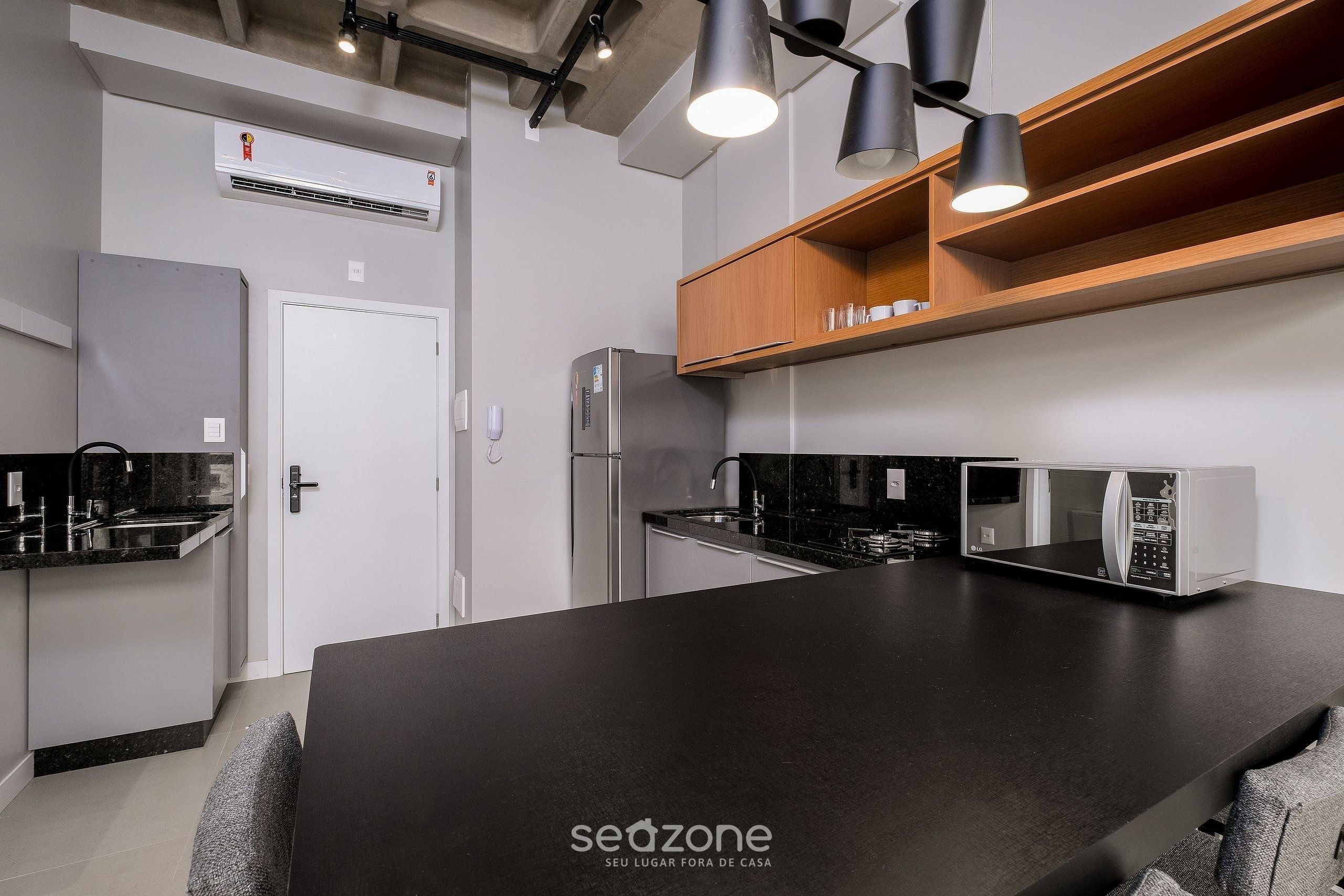 A modern kitchen with a central island, built-in appliances, and pendant lighting.