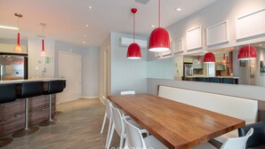 Una cucina moderna con un piano di lavoro in legno, forno integrato e frigorifero in acciaio inossidabile.