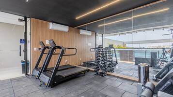 A gym with treadmills, dumbbells, and exercise equipment.