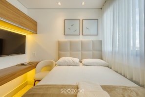 A modern hotel room with a bed, a desk, a chair, and a TV mounted on the wall. - Modern and Complete Stay in Brasilia - Epk0903 (Guará)