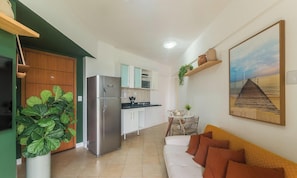 Un espacio habitable compacto con kitchenette, comedor y sofá.