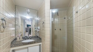 A bathroom with beige tiles, a granite countertop, a sink, a mirror, a handheld showerhead, and a towel ring. - Apt in Cond. w/ Pool, Steps fr the Beach Esn0702 (Salvador)