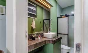 A bathroom with a white sink, green walls, a mirror, and a shower. - Studio the City Center 300m Pelourinho Hai0203 (Salvador)