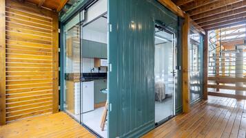 Interior de madera con una puerta corredera de vidrio que da a una cocina.
