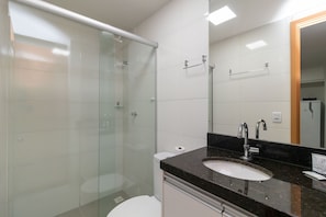 A modern bathroom with a glass shower enclosure, a white toilet, and a black countertop sink with a mirror. - 1BR Apartment, Self-checkin, Asa Norte Nor0202 (Brasília)