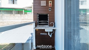 A small outdoor kitchen area with a sink and a hanging sign above it. - Practical apt 550m fr Canasvieiras Beach Rtba1361 (Florianópolis)