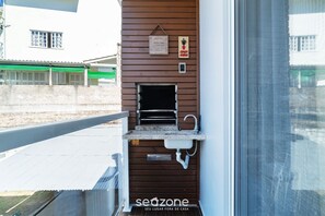 Ein kleiner Küchenbereich im Freien mit Spüle und einem hängenden Schild darüber.
