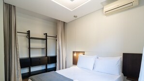 A hotel room with a bed, a bedside table, a wall-mounted air conditioner, and a built-in shelf. - Practical apt 550m fr Canasvieiras Beach Rtba1361 (Florianópolis)