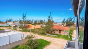 A residential area with houses, a dirt road, and a clear blue sky.