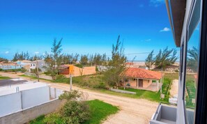 A residential area with houses, a dirt road, and a clear blue sky. - Loft 50 m From Camacho Beach Plo0010 (Jaguaruna)