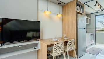Una cocina moderna con refrigerador integrado, armarios de madera y un comedor con dos sillas.
