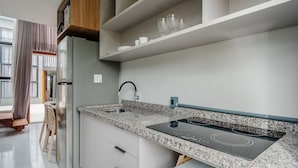 Una cucina moderna con un piano di lavoro in granito, forno integrato e frigorifero in acciaio inossidabile.