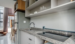 A modern kitchen with a granite countertop, built-in oven, and a stainless steel refrigerator. - Loft w/ Balcony 50m From the Beach Plo0004 (Jaguaruna)