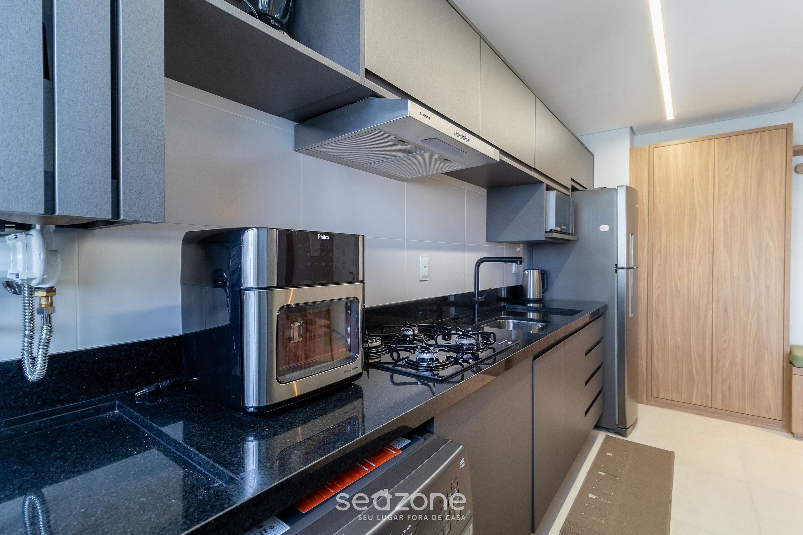Una cocina moderna con estufa a gas, horno y microondas integrados.