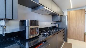 Una cocina moderna con estufa a gas, horno y microondas integrados.