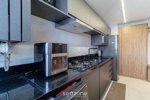 Una cocina moderna con estufa a gas, horno y microondas integrados.